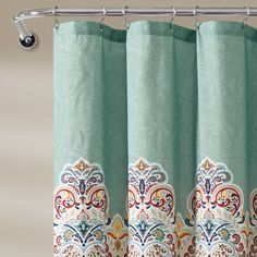 a shower curtain with an ornate design on it's side, hanging from a metal rod