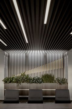 a long table with chairs and plants on it in front of a wooden paneled wall