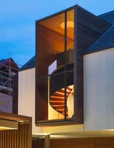 a spiral staircase is seen through the window of a modern home at night in australia