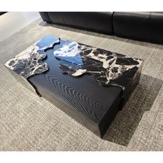 a black and white marble coffee table sitting on top of a gray carpeted floor