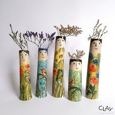 four vases with flowers in them sitting next to each other on a white surface