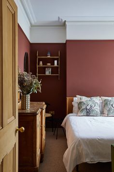 a bed sitting in a bedroom next to a wooden dresser