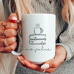 a woman holding a coffee mug with the words, mrs pullie on it in front of her