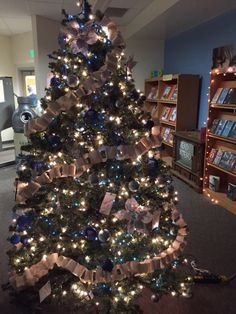 a decorated christmas tree in the middle of a library