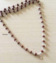 "Sterling Silver Rudraksha Necklace. This beaded necklace can be worn by men as well as women. This Mala can be worn in multiple ways, it can be worn as it is, or you can attach a pendant/tassel in the lock of this Mala to wear it as a pendant necklace. About Rudraksha:-- Rudraksha have been traditionally used as prayer beads. They are associated with Lord Shiva and the name Rudraksha translates to the Shiva's tears. They commonly worn by his devotees. They are worn as a form of protection as th Rudraksha Mala Silver For Men, Silver Rudraksha Mala, Spiritual Silver Beaded Necklaces For Puja, Spiritual Necklaces With Silver Beads For Puja, Traditional Necklaces With Silver Beads For Meditation, Spiritual Silver Beads Mala Gift, Silver Mala With 108 Beads As Gift, Handmade Brown Necklace For Puja, Brown Necklaces For Puja And Festivals