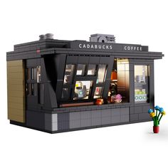 a lego model of a coffee shop with flowers in the foreground and an advertisement for cadbuck's coffee on the front