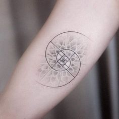 a tattoo on the arm of a person with a circular design in black and white