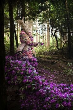 an image of a woman in the woods with purple flowers on her head, and texting that reads incredible floral installation by kristy mitchell