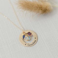 A beautiful golden gift for your Grandma or Mom. What better way to remind her of her family - a necklace personalized with names and birthstones representing each grandchild Product details MATERIAL: 14K Gold Pendant, Plated or Gold Filled ChainSIZE: 1 1/8" (28.575) pendantCHAIN LENGHT: 16", 18", 20" based on selectionCHAIN STYLE: cable, curb, rolo, double ropeBIRTHSTONES: Optional based on selectionENGRAVING: Up to 5 characters (including spaces) around the circumference of the washer Engraved Personalized Necklaces For Mom's May Birthstone, Mother's Day Round Pendant Birthstone Necklace With Name, Mother's Day Birthstone Necklace With Name On Round Pendant, Mother's Day Name Birthstone Necklace With Round Pendant, Personalized Birthstone Necklace With Round Pendant, Gold Nameplate Necklace With Birthstone, Personalized Mother's Day Birthstone Necklace Round Pendant, Mother's Day Personalized Round Pendant Birthstone Necklace, Personalized Round Pendant Birthstone Necklace For Mother's Day