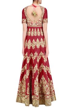 This set features a red flared anarkali suit in dupion base appliqued with floral pattern gold gota patti work and beads embroidered motifs all over the front and back ghera and yoke. It is handcarfted with sequins embellishment on the top and gold lace wide border around the hem. It has a deep keyhole at back and green dori tie up with fabric balls and gold and white beads tasseled hangings. It is paired with red satin lycra churidaar pants. It comes along with green net dupatta with gold sequi Red Raw Silk Churidar With Gota Work, Red Anarkali Style Raw Silk Churidar, Red Anarkali Sharara With Zari Work, Red Raw Silk Anarkali Set With Dupatta, Red Sharara With Zari Work, Festive Anarkali Set With Zari Work In Dola Silk, Red Anarkali Set In Dola Silk, Red Anarkali Salwar Kameez With Gota Work, Red Lehenga With Straight Kurta And Dupatta