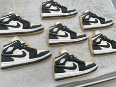 cookies decorated with black and white shoes are on a baking sheet in the shape of sneakers