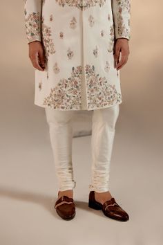 Opaline Sherwani | Jatin Malik Presenting our ivory placement hand-embroidered sherwani set, a true masterpiece. Crafted with meticulous attention to detail, this sherwani features a captivating embroidery design. The foundation is adorned with colorful resham threads, intricately woven with golden zari and dabka accents. The combination of these elements creates a stunning visual effect, showcasing the richness of craftsmanship and tradition. Perfect for those who appreciate refined elegance and intricate artistry, this sherwani set is bound to leave a lasting impression. Included in purchase: Sherwani, Kurta, Churidar Product Specification Color: Ivory Fabric: Linen silk Occasion: Engagement, Wedding, Bridal, Reception Style: Sherwani, Kurta, Churidar Care: Dry Clean Work: Hand Embroider Luxury Cotton Silk Sherwani With Naqshi Detail, Luxury Cutdana Sherwani For Traditional Ceremonies, Luxury Anarkali Style Sherwani For Weddings, Luxury Yellow Sherwani For Navratri, Luxury Brocade Long Sleeve Sherwani, Luxury Transitional Sherwani With Sequins, Luxury Floor-length Elegant Sherwani, Luxury Dola Silk Sherwani With Zari Work, Luxury Tussar Silk Sherwani With Resham Embroidery