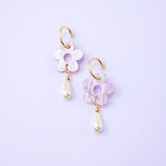 The Daisy Pearl Drops are elegant floral earrings that add a touch of class and polish to any outfit. Perfect for a fancy affair (wedding! date night!) or any occasion when you want to impress and glimmer! Hand-made in studio using beautiful marbled acrylic and glass pearls.  The drops hang from 18mm, 14 karat, gold-filled hoops and are removable so you can wear the hoops on their own—two earrings in one, perfect for travel! Uses 14 karat gold-filled hoops which are tarnish resistant and hypoallergenic Hand-made in New York City Elegant Lavender Flower Earrings For Gift, Elegant Purple Flower Earrings, Purple Bridal Earrings With Matching Set, Elegant Purple Flower Shaped Earrings, Delicate Purple Earrings For Wedding, Lavender Flower Earrings For Wedding, Elegant Lavender Flower Shaped Jewelry, Delicate Purple Wedding Earrings, Purple Flower Earrings For Wedding