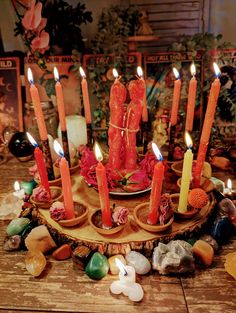 a candle holder with seven lit candles on top of rocks and stones in front of it