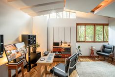 a living room filled with lots of furniture and electronics on top of a hard wood floor