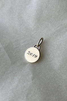 a silver charm with the word 2010 written on it