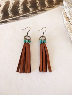 Brown Leather Fringe and Genuine Turquoise Earrings Brown leather fringe hangs from a antique brass ring and is wire-wrapped with genuine Campitos turquoise mined in Sonora, Mexico. Length is approximately 2.75 in. long (including ear wire). Earring hangs from a french-style ear wire. Shop all of our earrings HERE: https://etsy.me/3DFs84O Please let me know if you have any questions! All jewelry creations are handmade by myself in my smoke-free Arizona studio.  I can't wait to welcome you to the Leather Fringe Earrings, Pebble Jewelry, Earrings Diy Handmade, Diy Jewelry Earrings, Seed Bead Patterns, Southwestern Jewelry, Western Boho, Boho Festival, Genuine Turquoise