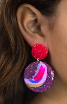 a close up of a person wearing some kind of earring with glitter on it