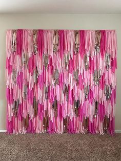 pink and silver wall hanging on the side of a room with carpeted flooring