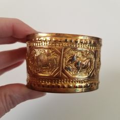 "Unique brass/ brass colored vintage bangle bracelet featuring an array of semi abstract animals.  It is aged and worn, adds to the charm! It is also a little bent. It is not marked so I am not sure the metal, possibly copper or brass Measures approx. 3\" diameter. 1 1/2 inches wide" Antique Brass Bangle For Gifts, Antique Brass Bangle Gift, Antique Bronze Brass Cuff Bracelet, Antique Gold Cuff Bracelet Bangle, Vintage Gold Stamped Bangle, Vintage Bronze Brass Bracelets, Ornate Antique Gold Brass Bracelets, Antique Bronze Bangle Gift, Vintage Gold Cuff Bracelet With Antique Finish