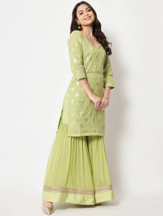 This is a beautiful 3-piece suit set. It comes with straight cut kurta with foil print detailing has 3/4th sleeves, v neck & short length teamed with flared sharara pants and a georgette banarasi dupatta. 3-piece set Color- Pista Green Work- Foil Print Detailing Kurti Length - 36 inch Kurta Fabric-Chanderi Bottom Fabric -Chinon Dupatta Fabric - Georgette Banarasi Dupatta. Sleeves-3/4th Sleeves Neck-V Neck Care - Dry Clean Eid V-neck Sets With Zari Work, Pista Green Palazzo Set With Gota Work, Pista Green Lehenga With Straight Kurta For Ladies, Traditional V-neck Sharara For Festive Occasions, Festive Green V-neck Sets, Festive Designer V-neck Sharara, V-neck Sets With Resham Embroidery For Festive Season, Festive V-neck Semi-stitched Sharara, V-neck Chanderi Sets For Diwali