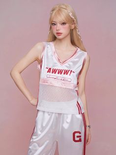 a woman in white and red basketball uniform posing for a photo with her hands on her hips