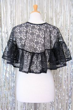 "A perfectly elegant (and splendidly old-fashioned!) black lace cape is just thing for a rose garden stroll, fashionable afternoon tea, or picnicking 'n wildflower picking!! With its pretty ruffles, romantic floral print, and darling bow ties...it's a Victorian style capelet smart enough for Wonderland!! Toss it over your shoulders, wearing the ties in the front or off to one side... and march out to make the most of the season!! -One size*: -15\" total length. -20\" neckline opening. -Adjustabl Feminine Spring Party Lace, Elegant Lace For Spring Party, Vintage Lace With Patchwork For Spring, Vintage Fitted Lace For Spring, Fitted Vintage Lace For Spring, Vintage Lace Patchwork For Spring, Spring Wedding Lace With Lace Collar, Black Lace For Spring Party, Wildflower Picking