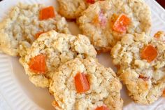 several cookies on a white plate with orange toppings