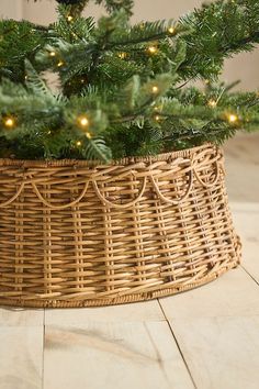 a christmas tree in a wicker basket with lights on the top and below it