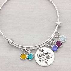 This grandmas blessings birthstone bangle bracelet makes a great keepsake for years to come. You can add birthstones later as needed. Two variations of this personalized bracelet are available: Smooth or twisted. INCLUDES: ♥ 3/4" disc with saying - Grandma's Blessings, Nana's Loves, Blessed Grandma, etc ♥ swarovski birthstone charms -choose number needed from pull down menu ♥ expandable stainless steel bangle bracelet (twisted 1st and 2nd pic, smooth 3rd pic Engraved for a permanent design that Adjustable Bangle Bracelets With Birthstone, Mother's Day Round Birthstone Charm Bracelet, Hand-strung Beaded Bracelets For May Birthstone, Hand-strung Bracelets As May Birthstone Gifts, Personalized Bangle Charm Bracelet For Mother's Day, Stamped Necklaces, Personalised Bangle, Stainless Steel Bangles, Birthstone Bracelets