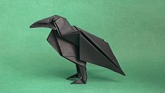 a black origami bird on a green background