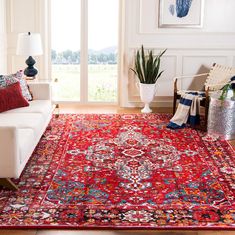 a living room filled with furniture and a red rug