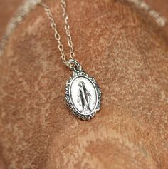 Sterling silver virgin mary necklace - religious necklace - catholic necklace - our lady necklace - virgin mary jewelry A sterling silver virgin mary hang pendant hanging on a 16 inch sterling silver chain. Please feel free to select a different length chain if you prefer. More from BubuRuby? https://www.etsy.com/shop/BubuRuby?ref=hdr_shop_menu Looking for other charm necklaces? https://www.etsy.com/shop/BubuRuby?section_id=12318467 More crystals and healers? http://www.etsy.com/shop/BubuRuby?se Dainty Silver Crucifix Necklace, Dainty Necklace With Miraculous Medal, Sterling Silver Miraculous Medal Jewelry, Spiritual Sterling Silver Necklace With Miraculous Medal, Silver Our Lady Of Guadalupe Necklace, Silver Jewelry With Miraculous Medal For Gift, Silver Miraculous Medal Jewelry As Gift, Silver Miraculous Medal Round Pendant, Silver Our Lady Of Guadalupe Pendant Jewelry