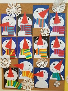 a bulletin board with snowmen on it and paper decorations hanging from the wall behind them