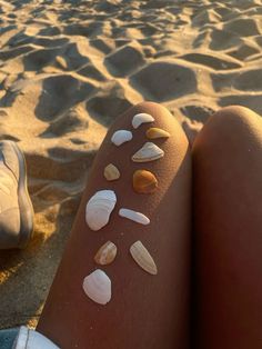 shells on the legs of a woman at the beach