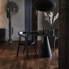 a dining room table with two chairs and a vase on the table next to it