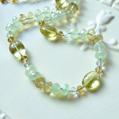 "This luxe gemstone necklace is a stunning piece of jewellery that you will treasure forever. Over four dozen sparkly beads are strung onto light blue silk cord, creating a stunning necklace of subtle colours. A tiny knot separates each stone, which results in a beautiful drape. The stones are about 4mm - 12mm in size, and contain lemon quartz in two shades of yellow, pale green amethyst, rich beer quartz, and mystic green chalcedony. This colour combination is unexpected and so pretty. A small Luxury Adjustable Hand Knotted Necklaces, Elegant Rondelle Crystal Necklace For Healing, Gemstone Rondelle Necklaces For Gifts, Elegant Amethyst Rondelle Necklaces, Gemstone Rondelle Necklace For Gift, Rondelle Gemstone Necklace Gift, Elegant Amethyst Rondelle Necklace, Elegant Adjustable Emerald Gemstone Necklace, Elegant Rondelle Emerald Necklace With Natural Stones