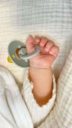 a baby is holding a pacifier in his hand