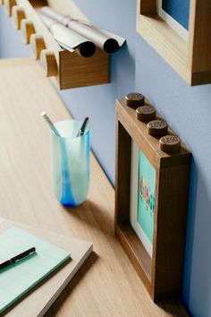 a wooden table with a blue vase and pen on it