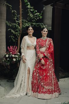 two women standing next to each other in red and white outfits, one wearing a long skirt