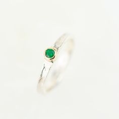 Tess, a beautiful gemstone Storybook ring set with your choice of sparkling gemstone. Featuring a rainbow of birthstone gems, Tess makes the perfect birthday gift. Set with the May birthstone, a beautiful green emerald. The storybook band is textured with the signature Storybook finish, a leather like design reminiscent of well loved and worn books. The edges move up and down organically as the silver gentle flows around your finger. They make the perfect ring worn on their own, or stacked with Emerald Bezel Setting Birthstone Ring For May, Emerald Birthstone Ring With Bezel Setting For May, Green Stackable Rings With Accent Stones For May Birthstone, Adjustable Emerald Ring As Gift, Adjustable Emerald Ring For Promise, Emerald Bezel Setting Promise Ring For May Birthstone, Green Emerald Birthstone Stackable Rings, Fine Jewelry Green Birthstone Stackable Rings, Fine Jewelry Green Stackable Birthstone Rings