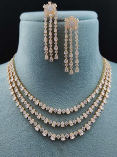 Experience the fusion of American innovation and Indian artisanship in our latest creation. Designed in the USA and meticulously handcrafted in India, this necklace set boasts american diamonds. Its design ensures effortless pairing with any ensemble, adding a touch of versatility to your jewelry collection. A symbol of boundless creativity and cross-cultural love, it's more than just a necklace – it's a statement of modern elegance. Handcrafted Metal: Metal Alloy, Gold Plated Necklace Set inclu Long Jewellery Necklace, Luxury Temple Necklace With Elegant Design For Wedding, Luxury Dual-tone Temple Jewelry Necklaces, Diamond Necklace Set Indian, Modern Indian Jewelry, American Diamond Necklace Set, Unique Locket, Bridal Necklace Designs, Fancy Jewelry Necklace