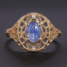 Why we love it:This Art Nouveau sapphire and diamond ring has an eye catching look with a bright cornflower blue sapphire set amidst ethereal filigree for a large yet delicate look. Bold, yet elegantly feminine, this beauty is an excellent choice for a stand out cocktail ring!Highlights:- 1.83ct oval shape sapphire with a gorgeous cornflower blue hue- Bright white and exceptionally clean diamond accents- 14k rose gold setting with filigree and engraved detailsDimensions:14.5mm across (north-sout Cornflower Blue Sapphire, Diamond Ring Vintage, Vintage Style Art, Sapphire And Diamond Ring, Sapphire Color, Sapphire Diamond Ring, Cornflower Blue, Gold Set, Ring Vintage