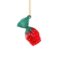 an ornament shaped like a strawberry hanging from a gold chain on a white background