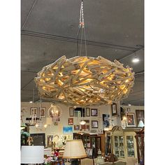 a large wooden light fixture hanging from the ceiling in a room with pictures on the walls