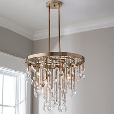 a chandelier hanging from the ceiling in a room with white walls and windows