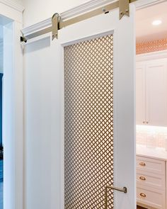 an open door in a kitchen with white cabinets