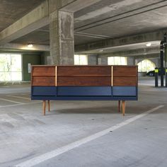 an empty parking garage with blue and brown furniture in the foreground, on concrete flooring