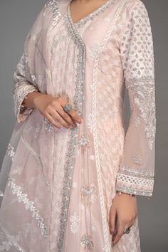 Light Pink Embroidered Anghrakha Style Pakistani Party Wear Frock embrace tradition in this gorgeous white ensemble with sequin and tilla motif details and delicate iconic flare. The angrakha is adorned with sequin sheets with thread outlines. Detailed Description: SKU: PB928 Detailing: Embroidery, Threads, Motifs, Dabka Color: Light Pink Fabric: Raw silk, Organza Design: Fully Embellished Dress with Embroidery Event: Party wear, Festive White Semi-stitched Anarkali Set For Designer Wear, Designer White Sharara With Dupatta, White Georgette Anarkali Set, White Bollywood Designer Anarkali Set, Designer Anarkali White Sharara, White Anarkali Designer Sharara, Designer White Anarkali Set For Diwali, White Anarkali Sharara For Designer Wear, White Anarkali Set For Designer Wear During Diwali