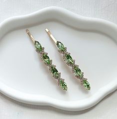 Add a touch of elegance to your hairdo with these stunning olive green crystal and gold diamante bobby pins. The perfect hair accessories for any occasion, especially weddings.  Made from high quality metal and features a sparkling gold finish, making them a great addition to any bridal or bridesmaid outfit.  Can be worn at proms, party and other formal occasions. You will receive 1 pair of hair clip for the price. Measurements: length 9cm, width 1 cm Ship with Royal Mail. Express delivery avail Wedding Light Green, Diamante Hair, Hair Accessories Green, Prom Hair Accessories, Wedding Barrettes, Women Hair Accessories, Bridesmaid Outfit, Green Crystal, Wedding Lights